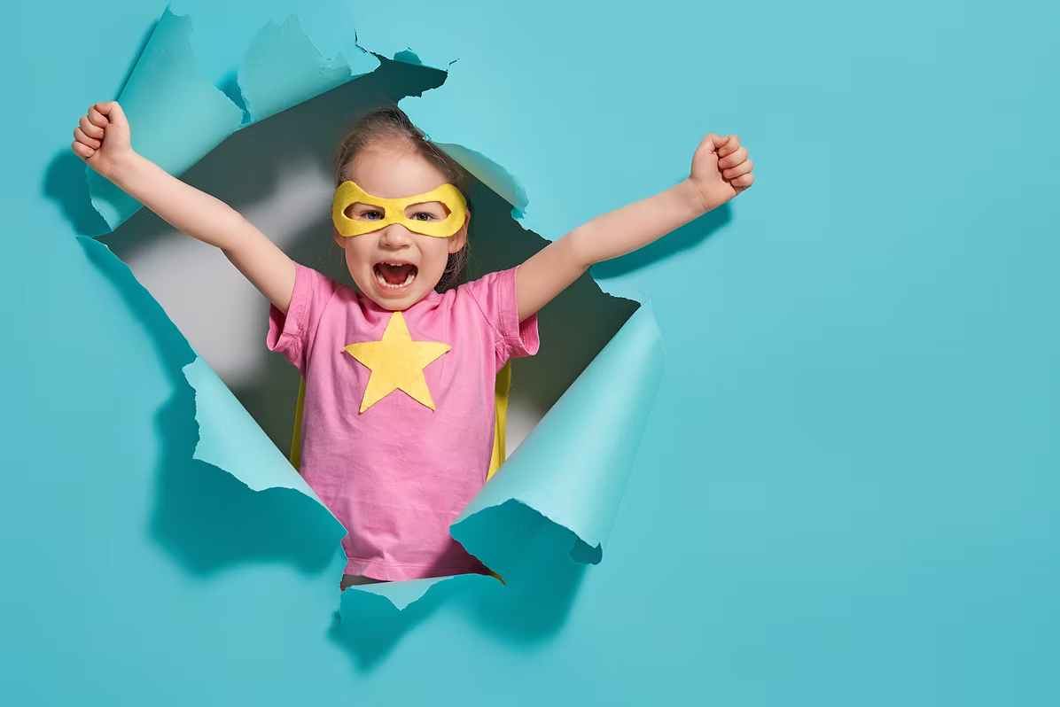 Girl in superhero costume celebrating